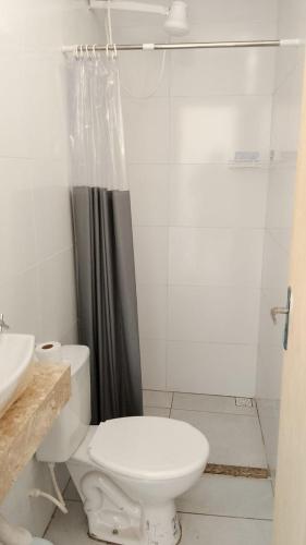 a white bathroom with a toilet and a shower at Casa temporada aracaju sergipe in Aracaju