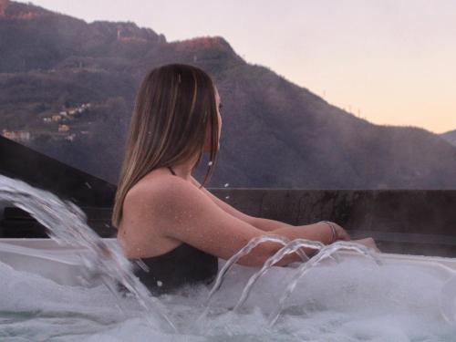 a woman sitting in the water in a hot tub at Casa Martina in Zogno