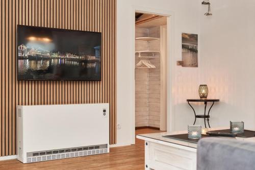 a living room with a flat screen tv on a wall at Horn sien Hus in Simonsberg