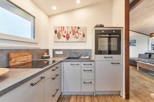 a kitchen with white cabinets and a stove top oven at Horn sien Hus in Simonsberg