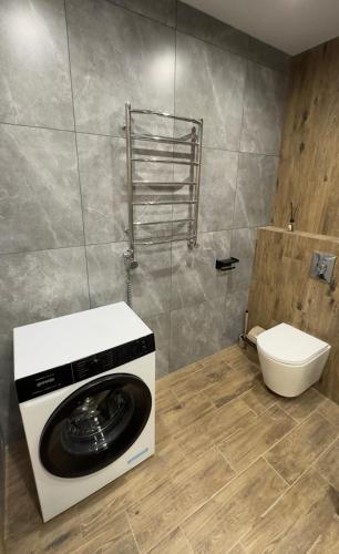 a washing machine in a bathroom with a toilet at Sunset apart in Kremenetsʼ