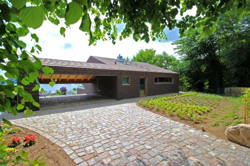 a house with a brick driveway in front of it at IDAHO - Hoog in Süderstapel