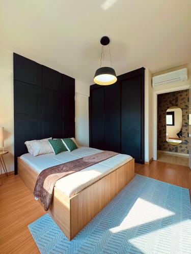 a bedroom with a large bed with a blue rug at Apartamento completo e elegante no centro de Pouso Alegre in Pouso Alegre
