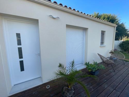 une porte de garage blanche sur une terrasse en bois dans l'établissement L annexe, à Fouras