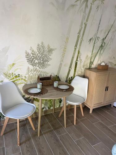 une salle à manger avec une table et deux chaises dans l'établissement L annexe, à Fouras