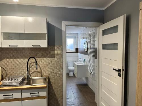 a small bathroom with a sink and a toilet at Noclegi na Heweliusza in Sanok