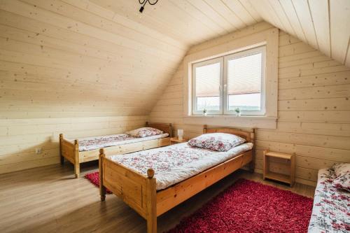 a bedroom with two beds in a room with a window at Orawska Sielanka in Roztoki