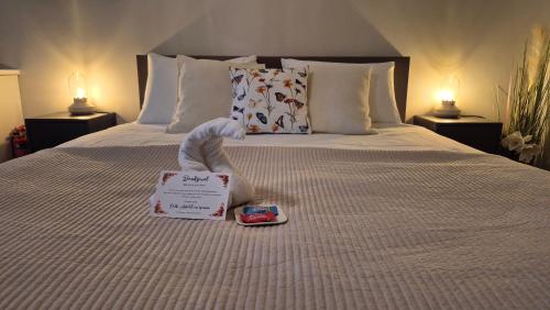 a bed with a stuffed animal on it with a book at Dalerheugte Drenthe B&B Comfort 5 met eigen badkamer en ontbijt à la carte op de kamer in Dalerveen