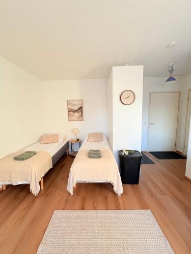 a room with two beds and a clock on the wall at Kodikas kerrostaloyksiö in Jalasjärvi
