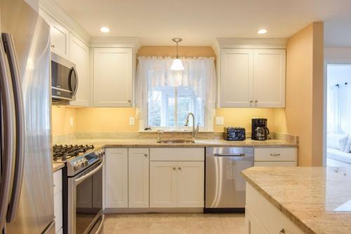 a kitchen with white cabinets and a sink at Spacious Home by Beach Dog Welcome in Brewster