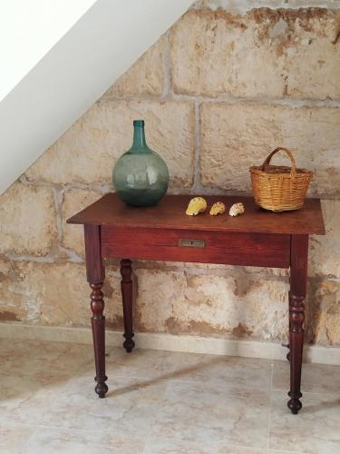 a green vase on a wooden table with a staircase at ca sa tia in Santanyi
