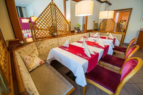 a dining room with two tables and a couch at BSW Ferienhotel Lindenbach in Bad Ems