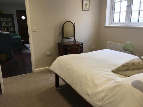 a bedroom with a bed and a mirror on a dresser at North Street annexe in Ilminster