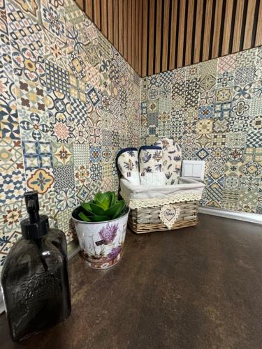 a room with mosaic walls and a chair and a bottle at Sofiamarholidays O Cantinho da Avó Bina in Moita