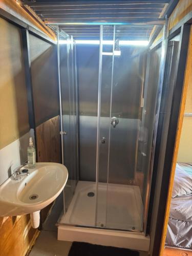 a bathroom with a shower and a sink at Okatjongoro Campsite in Gkamboro Settlement