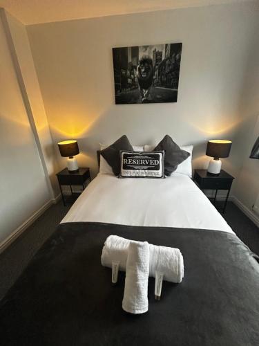 a bedroom with a bed with two towels on it at Park View House - Spacious 3 Bed Home in Burton in Burton upon Trent