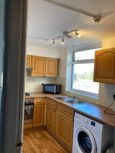 a kitchen with a washing machine and a window at Skylight Loft, 2 bed apartment, central Lancaster in Lancaster