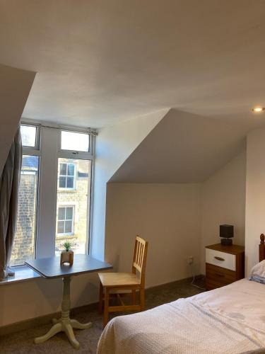a bedroom with a table and a bed and a window at Skylight Loft, 2 bed apartment, central Lancaster in Lancaster