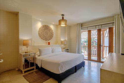a bedroom with a white bed and a large window at Casa Stella - Authentic Luxury Rooftop Pool in Cartagena de Indias