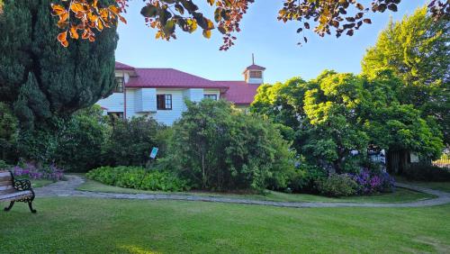 a park bench in the yard of a house at Hotel Casa Woerner - Caja los Andes in Valdivia