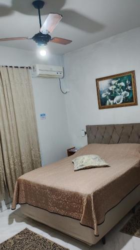 a bedroom with a bed and a ceiling fan at Cantinho aconchegante in Timbó