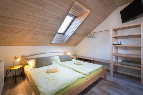 a bedroom with a bed with a wooden ceiling at Chalupa Máša in Liptovský Trnovec