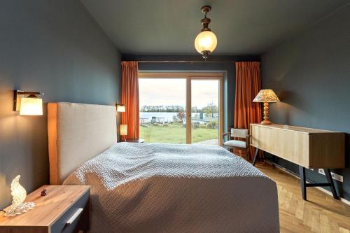 a bedroom with a bed and a desk and a window at IDAHO - Deep in Süderstapel