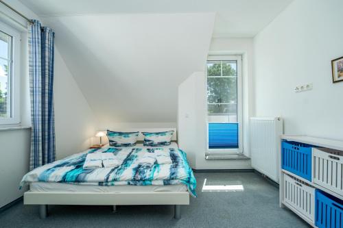 a white bedroom with a bed and a window at Ferienhaus "Stella Olivia" - Bade- & Saunawelt täglich inklusive in Lobbe