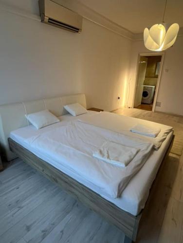 a large white bed in a room with at Greatforest apartman 2 in Debrecen
