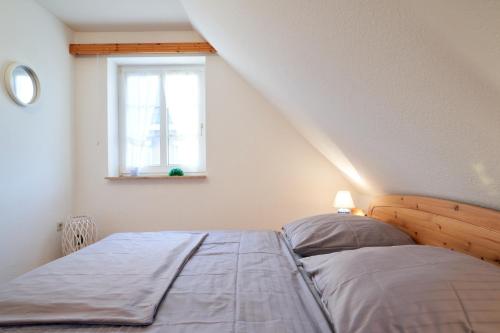 a bedroom with a bed and a window at Muschelsucher 2 in Nordstrand