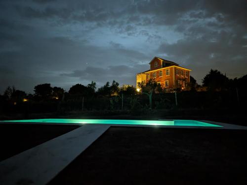 a house lit up at night with a swimming pool at Solar da Motta Douro Boutique Home in Ancede