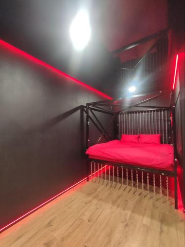 a room with a red bed in a dark room at RED Тематичні Апартаменти in Zhytomyr
