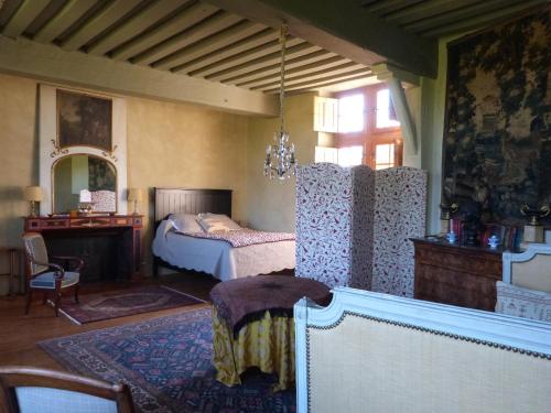 a bedroom with a bed and a table in it at Manoir du Plessis au Bois in Vauciennes