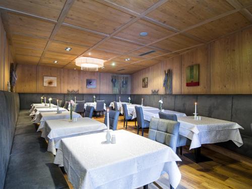a dining room with white tables and blue chairs at Alpinresort ValSaa - Sport & Spa in Saalbach Hinterglemm