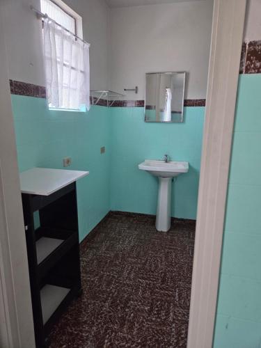 a bathroom with a sink and a mirror and a sink at Casa confortável e central in Poços de Caldas