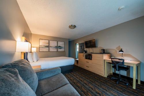 a hotel room with a bed and a couch at Courtesy Inn Downtown Eugene in Eugene