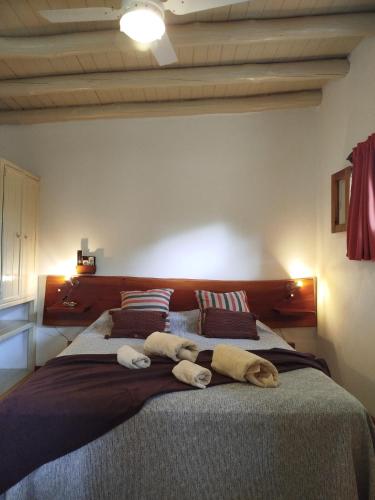 a bedroom with two towels on a large bed at Cabañas Entre Verde in Los Hornillos