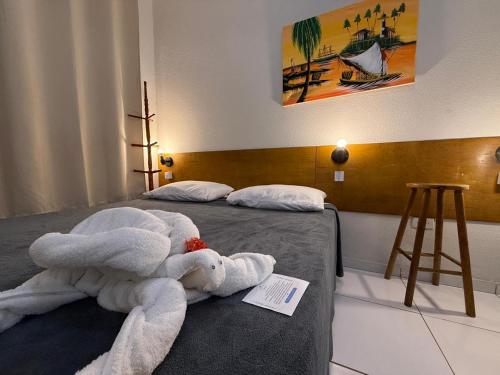a room with a bed with a stuffed animal on it at Pousada Sal e Mar Maracaipe in Porto De Galinhas