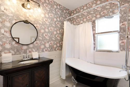 a bathroom with a sink and a tub and a mirror at Cruise the waterways from your backyard in Bradenton
