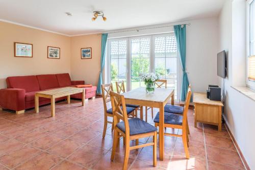 a living room with a table and chairs and a couch at Ferienwohnung Katharina EG in Wohlenberg