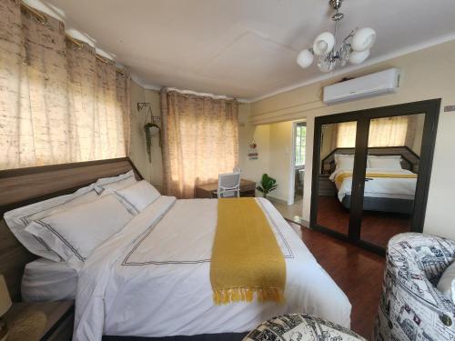 a bedroom with a large bed and a mirror at Silver Gates BnB in Mbabane
