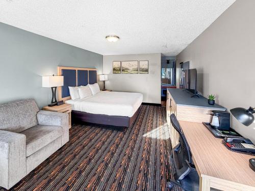 a hotel room with a bed and a couch at Courtesy Inn Downtown Eugene in Eugene