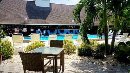 a table and chairs next to a swimming pool at Dolphin Key Resort - Cape Coral in Cape Coral