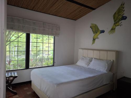 a bedroom with a bed with two birds on the wall at TierraViva in Tobia