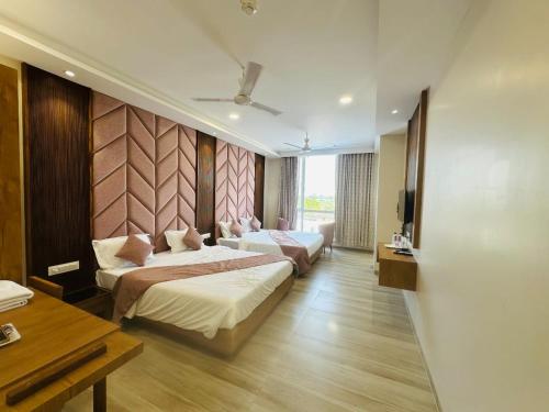 a hotel room with two beds and a television at Hotel Valley in Akteshwar