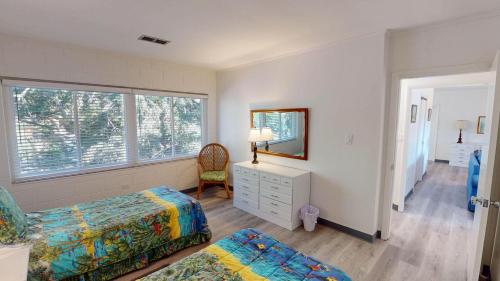 a bedroom with a bed and a dresser and a window at Atlantic Breeze #7 in Jekyll Island