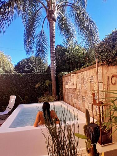 a pool with a palm tree and a person laying in it at Rincón de Paz Apart & Loft Suite Boutique - Adults Only in Villa Carlos Paz