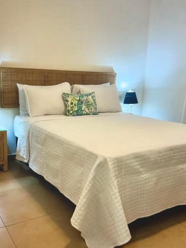 a bedroom with a large bed with white sheets and pillows at Palm Oasis Bonaire in Kralendijk