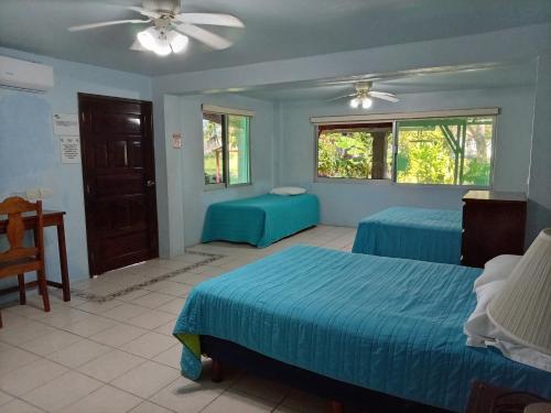 a bedroom with two beds and a ceiling fan at Freedom Shores "La Gringa" Hotel - Universally Designed in Isla Aguada
