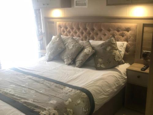 ein Bett mit weißen Laken und Kissen in der Unterkunft Annalake in Grange Over Sands
